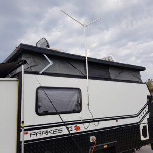 Caravan equipped with a digital TV aerial for enhanced reception parked at a campsite.