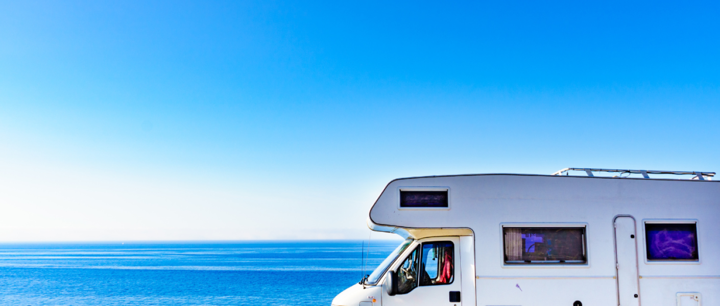 Caravan parked beside the beach with a TV Antennas for Caravans ensuring optimal reception even in remote locations.